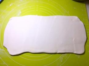 将对折好的面片再次擀成长方形，可以撒点干粉，这样更好擀