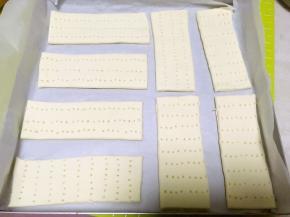 烤盘铺油纸，将切好的面片轻轻移到烤盘内，之后用叉子在面片上戳些洞洞，盖保鲜膜松弛半个小时