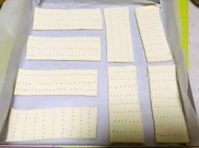 烤盘铺油纸，将切好的面片轻轻移到烤盘内，之后用叉子在面片上戳些洞洞，盖保鲜膜松弛半个小时