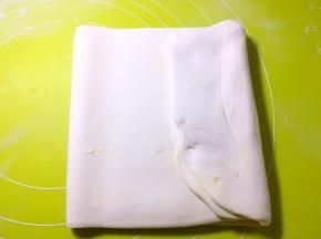 将擀好的面片对折，之后再折成三折