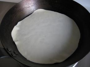 平底锅干锅烧至7成热，务必小火，放入擀好的饼