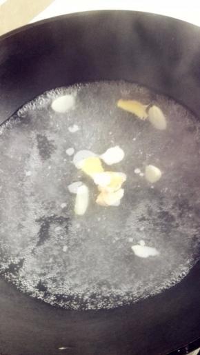 锅里烧水，放入蒜片、姜片，不要把水烧滚，刚开始冒泡的时候就可以