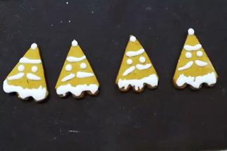 取适量糖霜装入裱花袋，并在姜饼上挤出圣诞老人的样子；