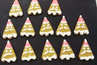 再取适量糖霜调入红色色素，挤在尖尖的头上便是圣诞帽了；