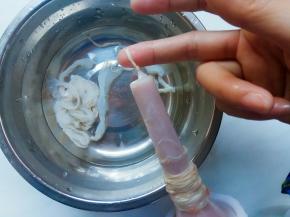 将一根羊肠先对半分。取半根套入灌肠器的管口，一点点撸到最顶端，套至末端底部打结。