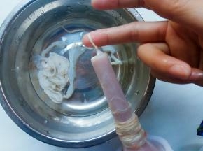将一根羊肠先对半分。取半根套入灌肠器的管口，一点点撸到最顶端，套至末端底部打结。