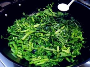 撒少许盐，先杀出茼蒿中的水分；撒盐后不要翻动茼蒿，让茼蒿平铺在锅底