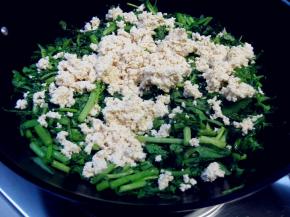 捏碎的豆腐放在茼蒿的上面，勿翻动，盖上盖子用小火焖一会；大约要5分钟时间