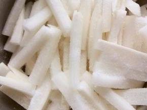 在萝卜条上撒适量的盐，用手翻拌均匀，腌制一至二个小时；盐的用量自行调整，一边腌一边尝，一个白萝卜大约放了5至6克盐