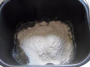 面包机桶里先放进鸡蛋液，再倒入墨汁水，放入除黄油外的所有材料