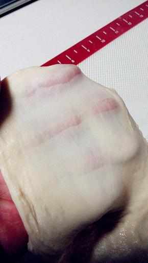 加入黄油继续揉面15分钟，软软的面团取出，但不沾手，已拉出手套膜