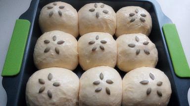 取出烤盘，烤箱预热，面团表面刷蛋液，放南瓜子