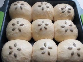 取出烤盘，烤箱预热，面团表面刷蛋液，放南瓜子