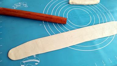 用擀面杖擀成较薄的长面皮。