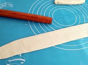 用擀面杖擀成较薄的长面皮。