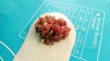 在面皮的一头放入肉馅。