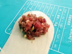 在面皮的一头放入肉馅。