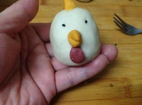最后，用叉子在鸡胡上压上些花纹，用黑芝麻沾到两边做眼睛