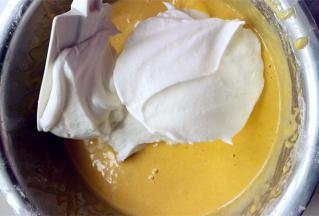 取1/3的蛋白霜放入蛋黄糊的盆中，用刮刀翻拌均匀