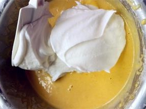 取1/3的蛋白霜放入蛋黄糊的盆中，用刮刀翻拌均匀