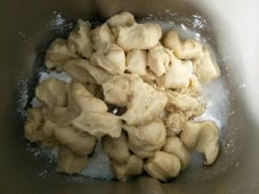 主面团材料除黄油外，全部放进面包机，发酵好的中种面团撕成小块一起放入，启动和面程序揉成团