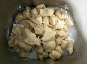 主面团材料除黄油外，全部放进面包机，发酵好的中种面团撕成小块一起放入，启动和面程序揉成团