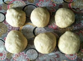 发酵好的面团按压排气，分成六份滚圆，盖住保鲜膜松弛15分钟