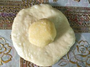 把面团压扁，包住椰蓉馅收口