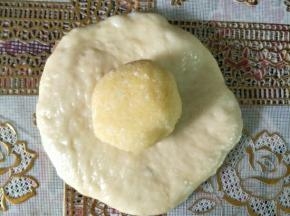 把面团压扁，包住椰蓉馅收口