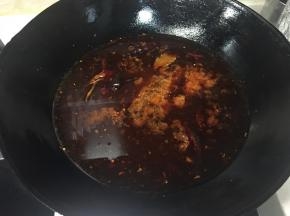 加入半锅的猪骨汤，大火烧开成为红油锅底。