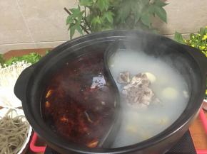 把鸳鸯砂锅洗净，分别把骨头汤和红油锅底倒入锅里，开电陶炉煮沸，加入鱼头和鱼骨到红油锅里先煮。（白锅底汤放些盐调味）白汤里先加入耐煮的白萝卜和红薯粉先煮。