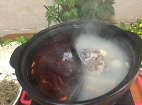 把鸳鸯砂锅洗净，分别把骨头汤和红油锅底倒入锅里，开电陶炉煮沸，加入鱼头和鱼骨到红油锅里先煮。（白锅底汤放些盐调味）白汤里先加入耐煮的白萝卜和红薯粉先煮。