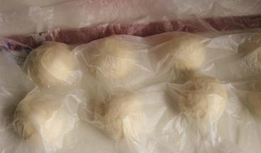 取出面团，按压、排气、分割成均等的七分，滚圆，盖保鲜膜进行醒发15分钟