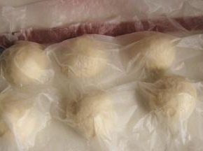 取出面团，按压、排气、分割成均等的七分，滚圆，盖保鲜膜进行醒发15分钟