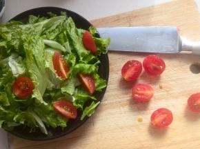 生菜浸泡后清洗干净，撕成小块放入盘中；圣女果洗净后对切，摆放在生菜上