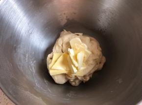 厨师机开启3档和面，面团出筋后加入提前软化的黄油，继续4档揉面