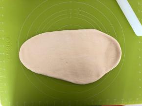 面团取出来放在揉面垫上用擀面杖擀扁排气