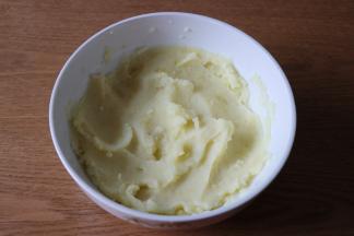 用勺子将蒸熟的土豆片压成泥；