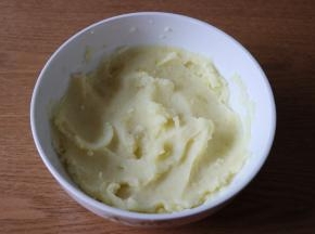 用勺子将蒸熟的土豆片压成泥；