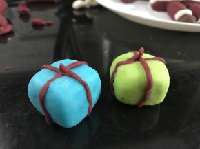 用蓝色和绿色的米粉团做成礼物合子。