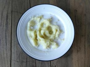 在土豆泥倒入少许细盐，再倒入牛奶，均匀搅拌