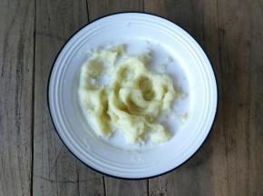 在土豆泥倒入少许细盐，再倒入牛奶，均匀搅拌