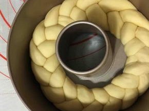 编好的辫子放入八寸活底蛋糕模具中发酵一倍大。
