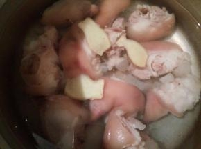 电饭锅里放适量清水，加猪脚，生姜片，料酒少许，盖盖子焖一个半小时
