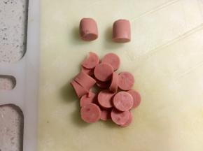 火腿剥好，头尾的部分切下来，做雪人的帽子，中间部分切片，可以切碎一些更好包。