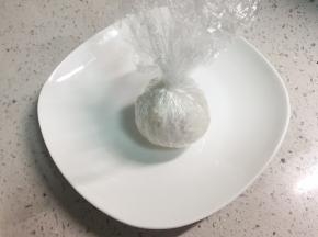 把保鲜膜收紧，米饭把火腿和芝士包住，团成圆饭团。