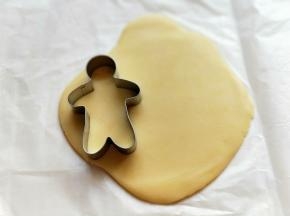 15分钟后，取二张油纸，把面团上下各垫一张，用擀面杖擀圆饼，约2 mm。再用姜饼模具压出姜饼人即可。依次将面团做完。