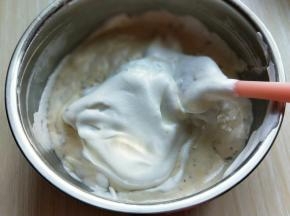 再取三分之一的蛋白霜加入蛋黄糊中，继续上面的手法，翻拌直至看不到蛋白霜。