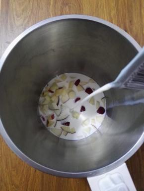 3、豆浆机中加入山药和苹果块，再加入牛奶。