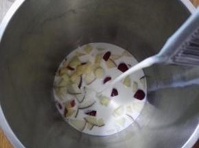 3、豆浆机中加入山药和苹果块，再加入牛奶。